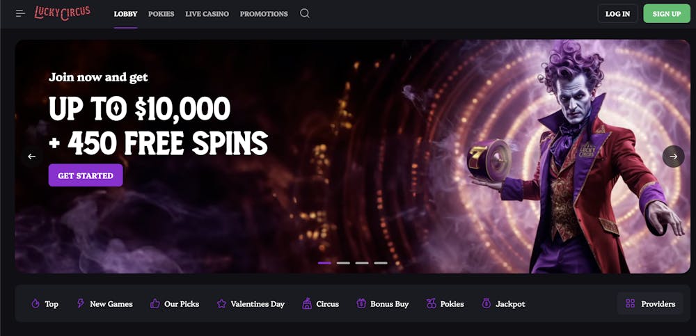 A dark-themed casino homepage featuring a promotional banner offering up to $10,000 and 450 free spins. The central image depicts a mysterious circus-themed character with purple hair, wearing an elegant red and gold suit, holding a roulette wheel.