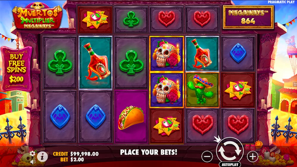 Muertos Multiplier Megaways slot screen showcasing a colourful grid with festive symbols like decorated skulls, tacos, tequila bottles, cacti, and sombreros. The vibrant Mexican-themed background features balloons, papel picado, and festive arches, with 'Megaways 864' displayed at the top.