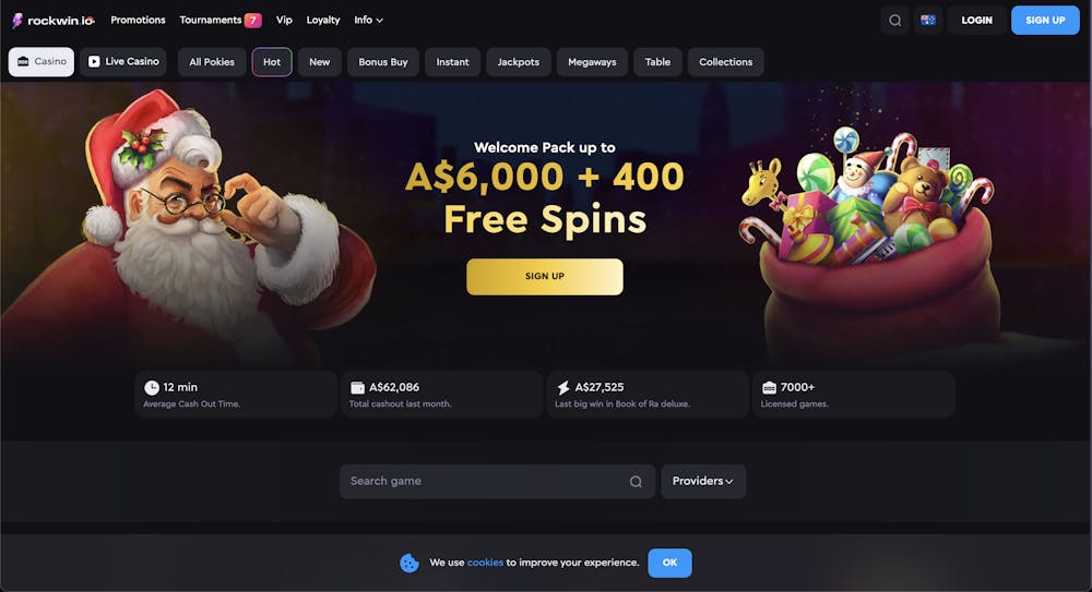 Rockwin casino homepage with a festive Santa and a sack full of gifts promoting a welcome pack of A$6,000 and 400 free spins. Icons below highlight cashout time, total cashout amounts, and the number of licensed games.